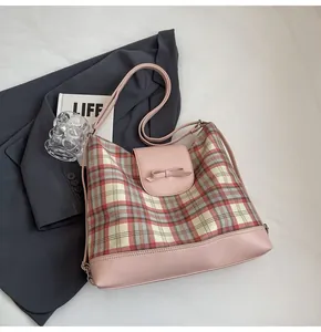 Detailansicht der rosa karierten Tragetasche mit Lederschleife auf einem Blazer