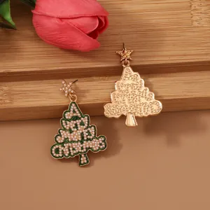 Close-up of golden Christmas tree earrings with colorful beads, pearls, and star tops