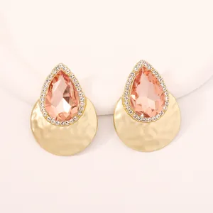 Dettaglio degli orecchini a goccia con zircone rosa e finitura in metallo martellato