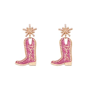 Détail de boucles d'oreilles bottes de cow-boy roses avec perles et texte Bride