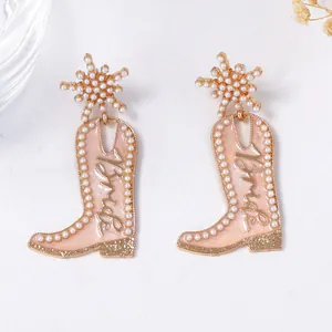 Vue détaillée de boucles d'oreilles bottes de cowboy pêche avec texte Bride et perle