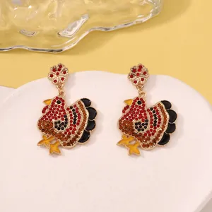 Detailed view of turkey-shaped drop earrings featuring red and yellow rhinestones