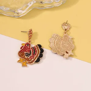Detail of turkey earrings with colorful rhinestones and enamel on a split background