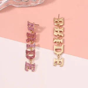 Detail der BRIDE Buchstaben-Ohrringe mit rosa Strasssteinen und Vergoldung