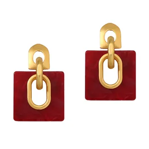 Vista de detalle de los pendientes retro geométricos en oro mate con resina roja