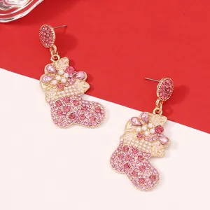 Detail of gold Christmas stocking earrings with pink rhinestones and white pearls