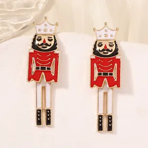 Elegant Nutcracker stud earrings in red and gold finish on a white display stand