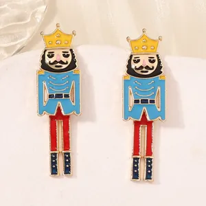 Nutcracker soldier earrings with colorful enamel finish on white display stand