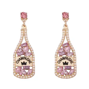 Detalle de pendientes de botella de champán con strass y contorno de perlas