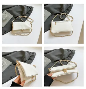 Close-up of white lychee pattern leather shoulder bag with golden chain and zipper details