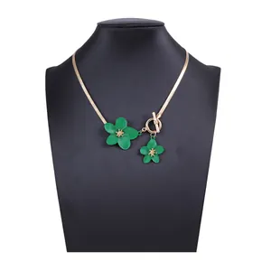 Detail of green flower pendants on golden flat snake chain with stylish OT toggle clasp