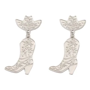 Detailed close-up of silver cowboy hat and boot earrings with intricate western carvings