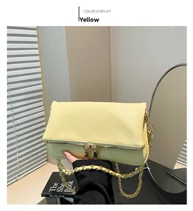 Detail of yellow lychee grain leather crossbody bag with gold chain and double zippers
