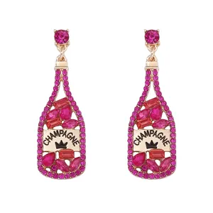Detalle de pendientes de botella de champán con diamantes rosa y base de metal oro