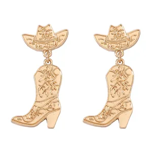 Detailed close-up of gold cowboy hat and boot earrings with intricate scroll patterns