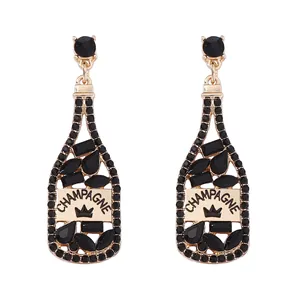 Detalle de pendientes con forma de botella de champán con diamantes negros y oro fino