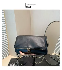 Detail of black lychee grain leather crossbody bag with gold chain strap and zipper