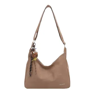 Sac à bandoulière marron en daim avec sangle réglable et breloque petit ours