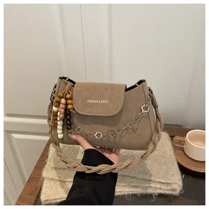 Détail du sac à bandoulière marron avec poignée en corde tressée et chaîne bohème