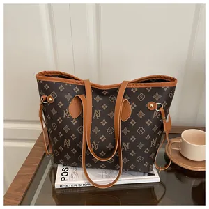 Classic monogram tote bag with double handles shown on a wooden desk with a coffee cup