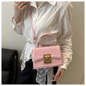 Pink retro crossbody bag detail featuring a golden geometric lock and a leather top handle