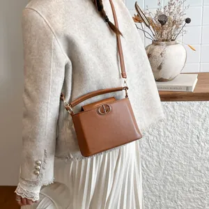 Sac seau classique en cuir marron avec boucle dorée et bandoulière polyvalente