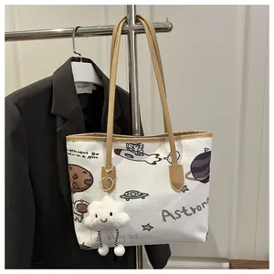 Detail of canvas tote with astronaut print, khaki straps and smiling cloud pendant
