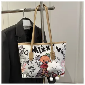 Detail of graffiti canvas tote bag featuring cartoon bear patterns and cloud plush charm