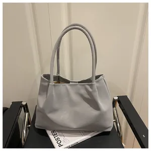 Detail van een lichtgrijze leren shopper met zacht geplooid ontwerp op een moderne stoel