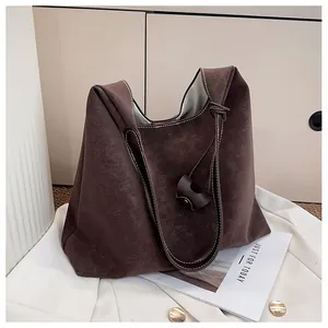 Macro shot of dark brown tote bag with vintage texture and long shoulder strap
