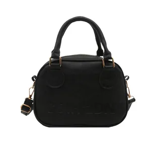 Vintage black shell handbag in oil leather finish with adjustable shoulder strap and top handles