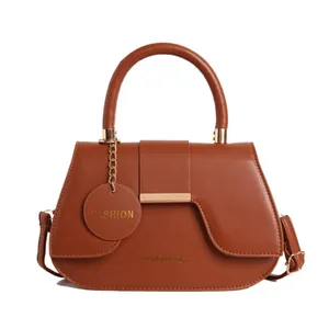 Brown PU leather saddle bag with top handle and gold hardware in front view