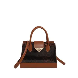 Brown crocodile embossed handbag with snake print detail and golden clasp