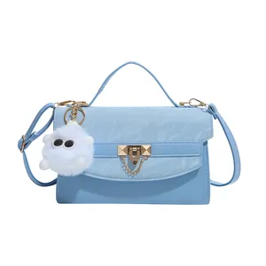 Sac à main bleu clair minimaliste avec cuir plissé, fermoir doré et pendentif en peluche
