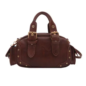 Retro dark brown Boston bag with golden buckles and high-quality leather texture