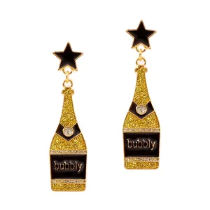 Close-up of champagne bottle earrings with golden glitter and black enamel stars