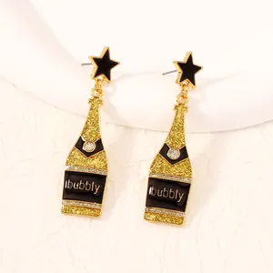 Detail of champagne bottle drop earrings with black enamel star stud and bubbly text