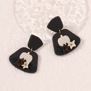 Handmade polymer clay earrings with Halloween pumpkin and floral motifs on black base
