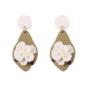 Handmade flower earrings featuring green polymer clay leaves and white floral accents