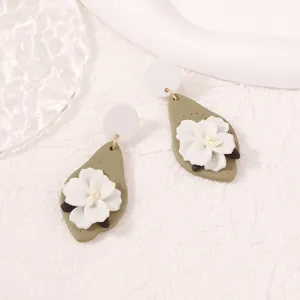 Olive green and white leaf floral clay earrings with gold accents on white paper
