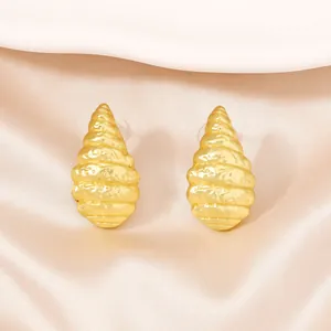 Elegante gouden spiraal oorbellen met getextureerde metallic afwerking op zijde