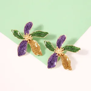 Makroaufnahme von Vintage-Ohrsteckern mit glitzernden lila und grünen Blütenblättern