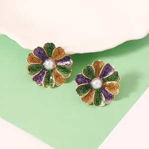 Nahaufnahme der Retro-Ohrstecker in Blumenform mit Glitzer und Perle im Zentrum