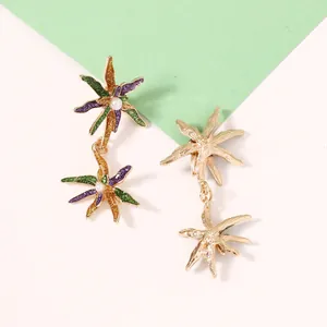 Détail macro de boucles d'oreilles étoile de mer avec paillettes et perle blanche