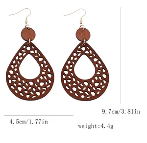 Detail view of brown cutout wooden earrings with teardrop shape and size measurements