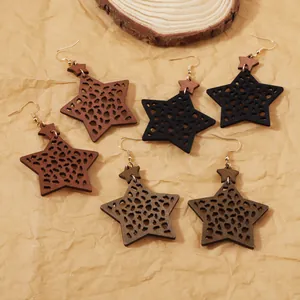Vue détaillée de boucles d'oreilles étoiles en bois bohème avec motif léopard découpé