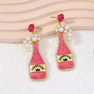 Creative pink champagne bottle earrings with pearls and glitter details for women