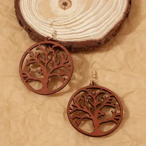 Boucles d'oreilles Arbre de Vie en bois faites main avec crochets dorés sur fond boisé