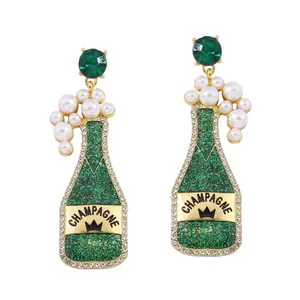 Detail of green champagne bottle earrings with rhinestones, pearls and champagne text