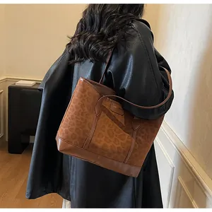 Chic leopard print suede tote bag styled with a black leather coat for a modern urban look